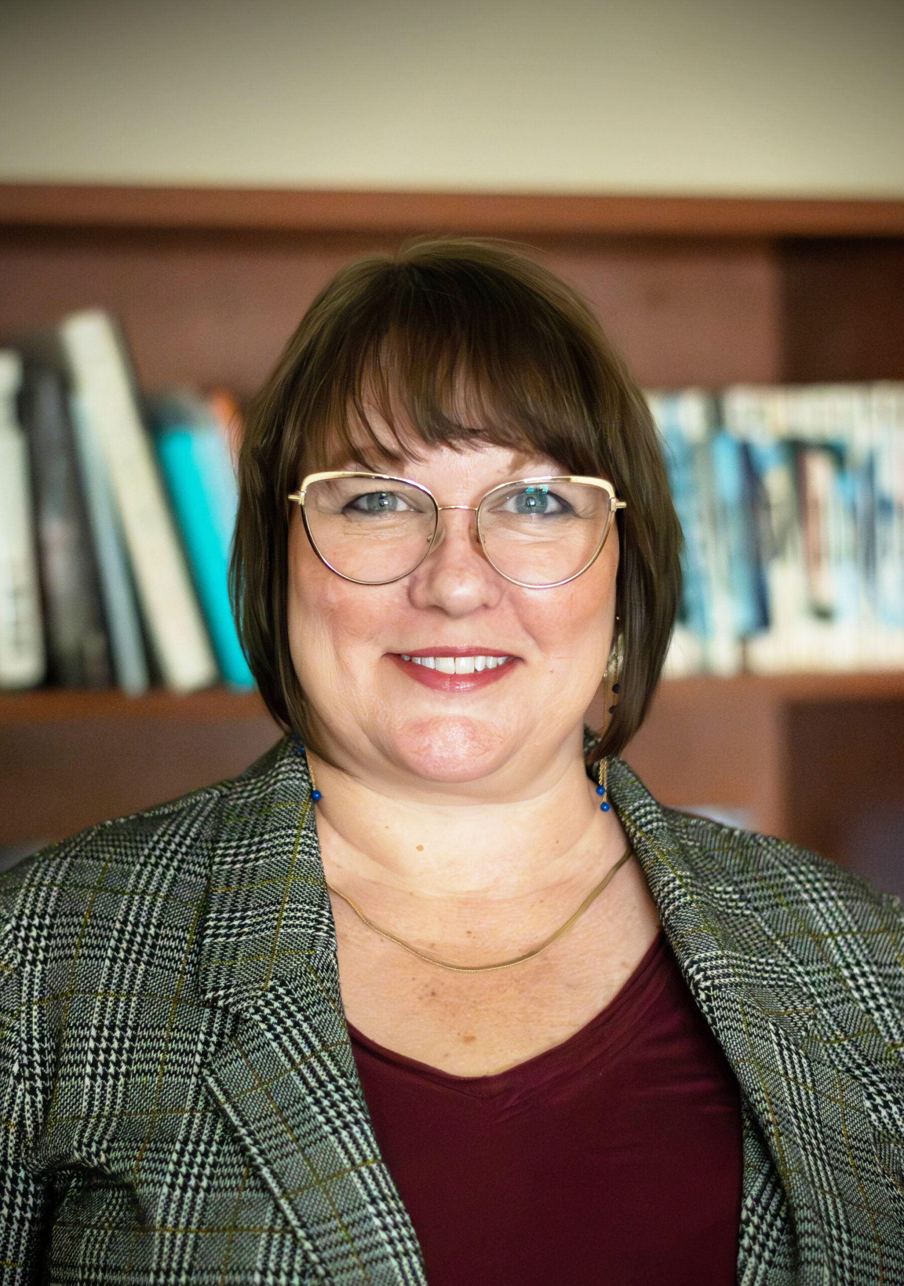 Headshot of Dr. Siobhan Scarry, in front of a shelf of books