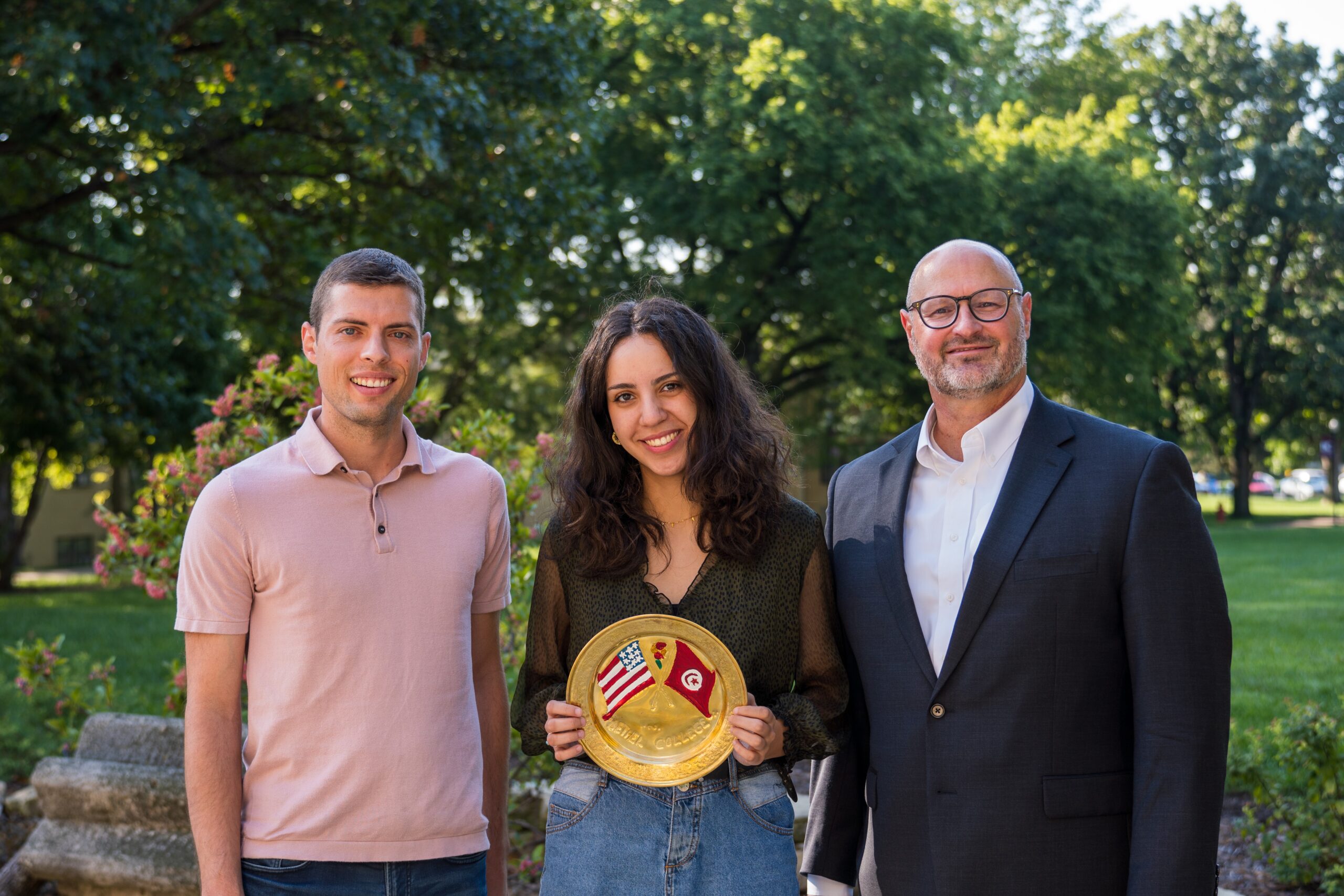 Eric Preheim, Meriem Dhouibi with the commemorative Tunisian plate, President Jon Gering