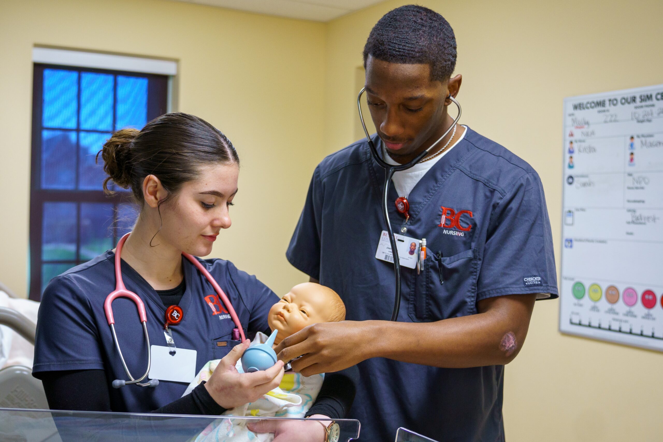 Two nursing students with a baby mannequin