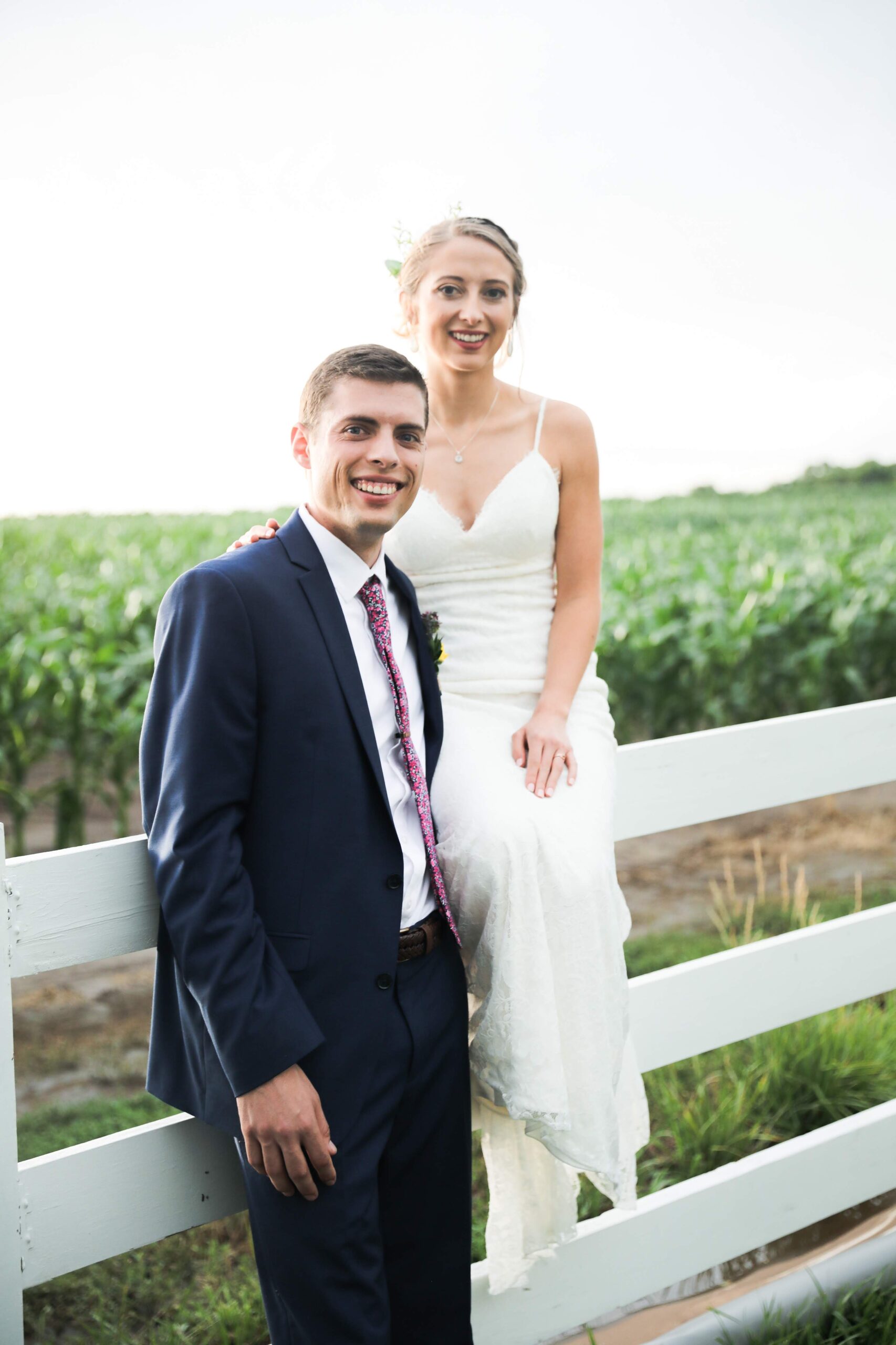 Eric Preheim & Kiley Varney; one of the wedding photos taken outdoors next to a white board fence
