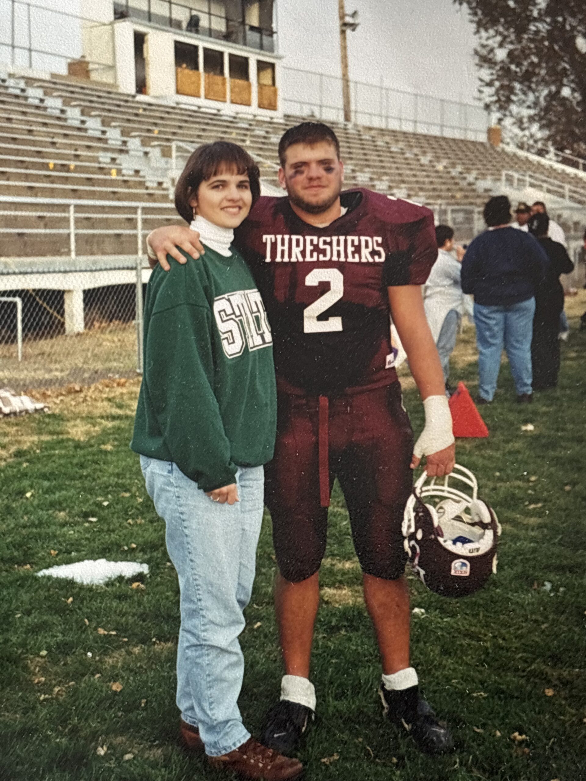 Tara Friesen and Matt Maltsberger on the football field, Matt in Thresher uniform (maroon)